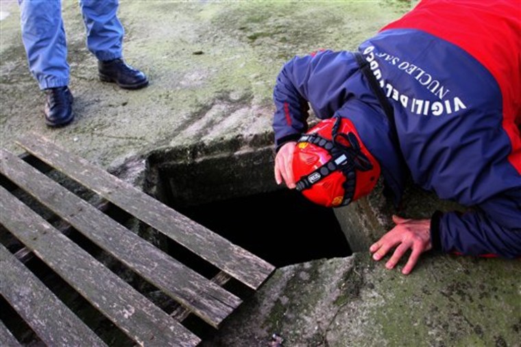 A firefighter looks inside a hole Monday for two 6-year-old twin girls who disappeared after their father died in an apparent suicide, in Cerignola, near Bari, Italy. The twins disappeared after the body of their father Matthias Kaspar Schepp, 43, a Canadian-born resident of Switzerland, was found by a railway station near the southern Italian port city Bari shortly before 11 p.m. on Feb. 3.